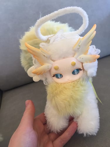 Customer holding the soft Angel Cat-Loong plush. It's white and yellow with a detailed plastic face and fluffy tail.
