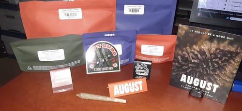 Customer's collection of Greenhouse Smalls in assorted colorful pouches, displayed on a desk with a pre-roll.