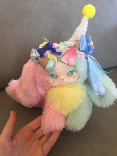Reviewer holding the colorful Melon Ice character from the Tutulong Fantasy Creatures plush series.