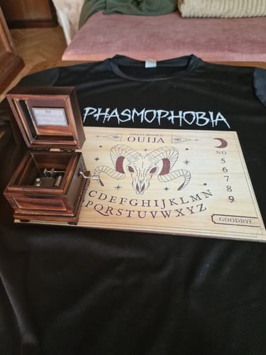 Customer's open, dark wood Phasmophobia Music Box displayed next to other game merchandise.