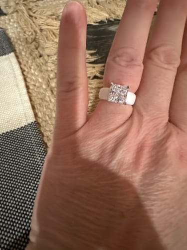 Customer's hand wearing the white Silicone Ring with a large, sparkling princess-cut stone.