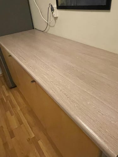 Nærbilde av Santana Eik Kalk kontaktplast med trestruktur på en benkeplate.