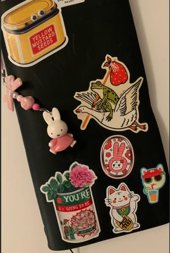 Customer's Miffy charm with a pink figure and beads, attached to a black surface covered in stickers.