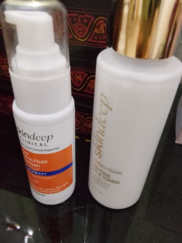 Customer's Barrier Defense Fluid Sunscreen bottle sitting next to a bottle of Dream Glaze Peptide Milk Toner.