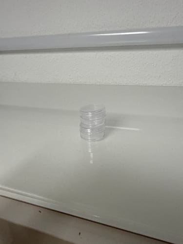 Kunde zeigt den kleinen, durchsichtigen Behälter für die 4-DMC Research Chemical.