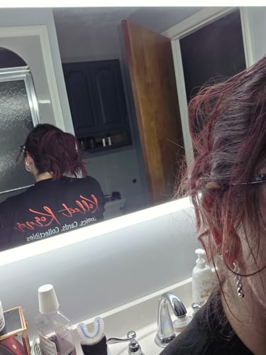 Reviewer's mirror selfie showing her reddish hair held securely in a low twist by a cloud clip.