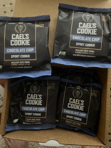 Reviewer's open box showing several individually wrapped Cael's Chocolate Chip Sport Cookies.