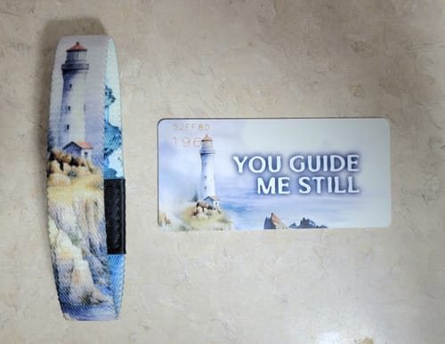 Reviewer's You Guide Me Still Bracelet featuring a detailed lighthouse scene, shown with its matching card.