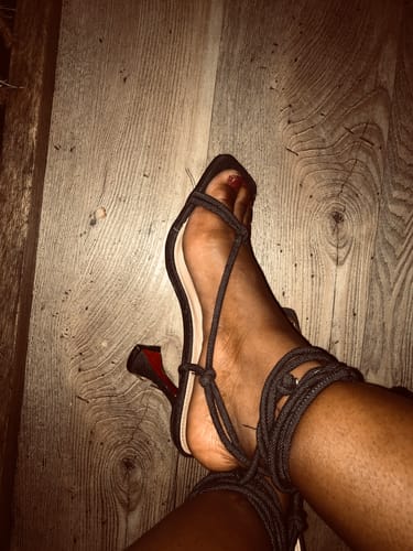 A close-up of a reviewer wearing the dark, strappy Denim Open Toe Short Heel Shoes.
