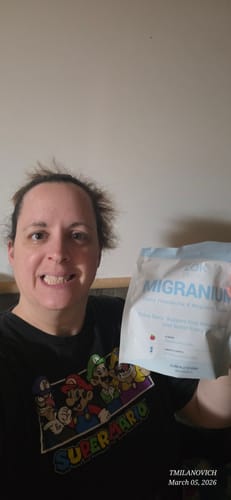 Customer happily holding a white and blue pouch of Migranium.