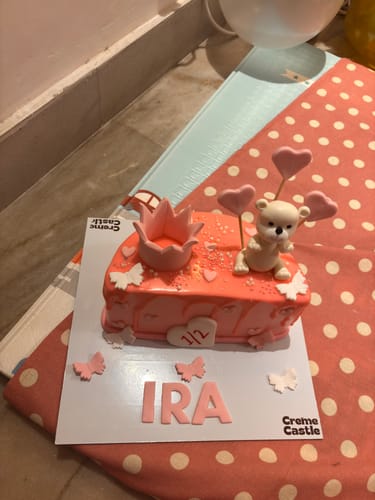 Customer's pink 6 Months Teddy Cake decorated with a crown, a teddy bear, and personalized with the name 'Ira'.