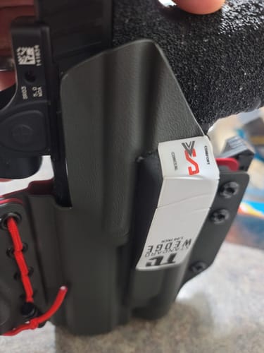Close-up of a reviewer's T1C wedge attached upside down to a black holster.