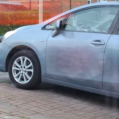 Partial view of a customer's light blue car with very clean alloy wheels after using The Apex Warrior Kit.