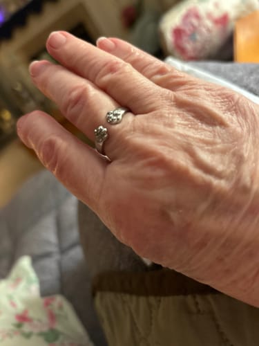 A reviewer's hand wearing the silver Paw Hug Ring, which wraps around their finger.