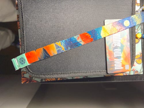 Customer's colorful Dreaming Out Loud string with a mint green tip laid across a dark textured case.