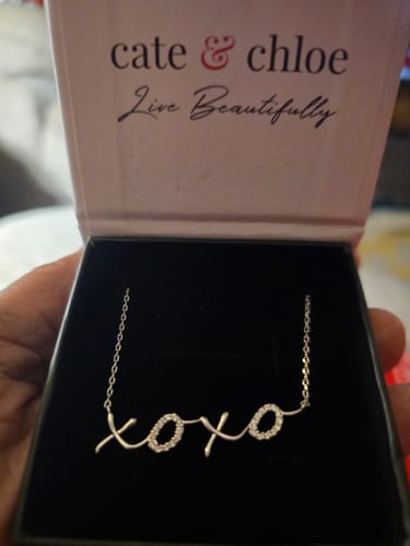 Reviewer showing the Jocelyn XOXO Pendant Necklace with sparkling crystals inside its Cate & Chloe gift box.