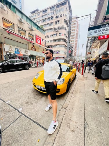 Reviewer standing on a city street wearing the brown square Noir sunglasses.