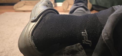 Close-up of a customer wearing the black Quarter Socks inside a clog-style shoe, showing the texture.