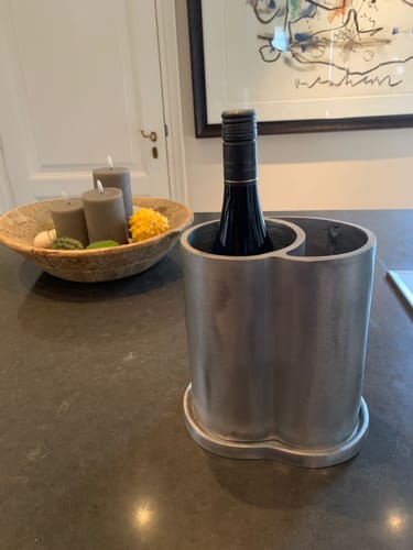 Recensent toont de stoere Surface Wijnkoeler met een fles wijn op een donker aanrecht.