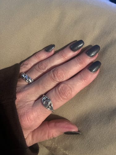 Customer's hand wearing the sterling silver Aquamarine Stars Moon Ring on their ring finger.