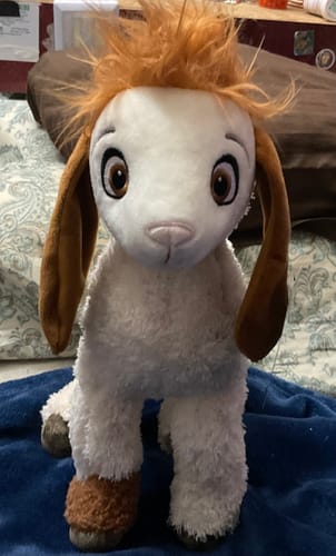 Customer's Tali Plushie sitting upright, showing its white fluffy body, orange hair, and long brown ears.