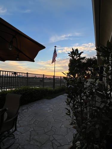 Customer's heavy duty American flag on a flagpole in their backyard patio at sunset.