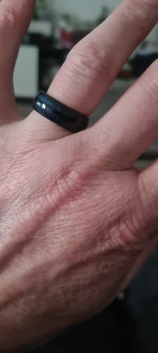 Close-up of a reviewer's hand wearing the black Nyros ring with a subtle blue inlay.