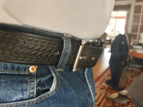 Reviewer's close-up of the thick, patterned Marshall belt worn with jeans.