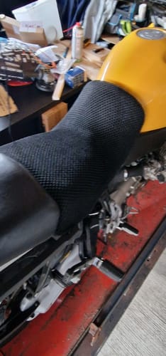 Customer's black Wind Rider Seat Cover with a textured finish, fitted on a yellow motorcycle seat.