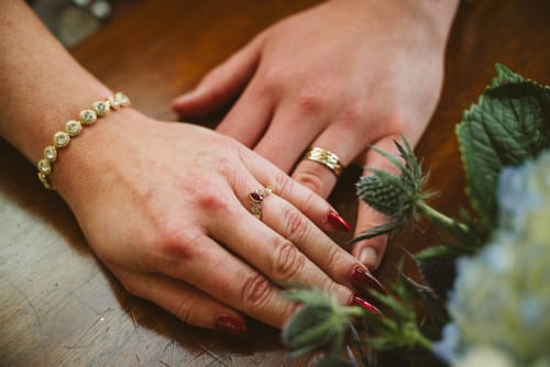 Customer's hands with shiny red Love Language press-on nails, worn for a wedding.