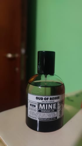 Recensore mostra il flacone del profumo 'Oud of Roses' di MINE Perfume Lab.