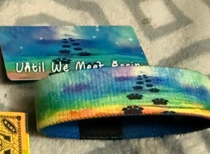 Customer's Until We Meet Again Bracelet and its matching card, both featuring a colorful rainbow design with paw prints.