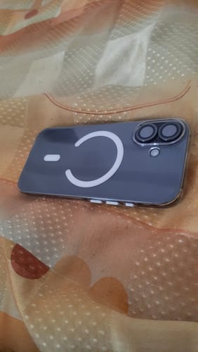 Customer's smartphone in a clear case, protected by the UltraShield Tempered Glass, resting on patterned fabric.