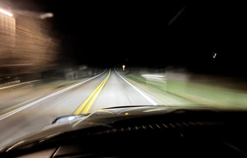 Reviewer's view from a moving car at night, with the road ahead brightly lit by the Carifex 6000K LED Headlight Set.