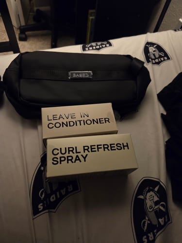 Reviewer's Hydration & Refresh Duo, showing the black toiletry bag with the boxes for the Leave In Conditioner and Curl Refresh Spray.