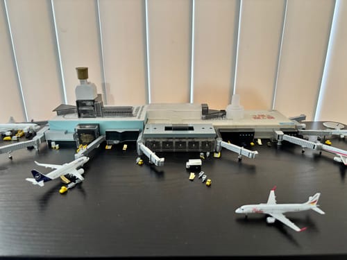 Reviewer's detailed model airport diorama with several die-cast airplanes parked at terminal gates.