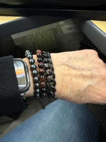Customer wearing the dark beaded 00 Buck Magnetic Hematite Titanium Bracelet with other bracelets on their wrist.