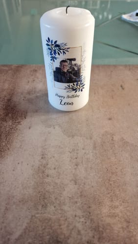 Ein Rezensent zeigt die personalisierte Geburtstagskerze mit einem Foto, blauem Blattdekor und dem Namen 'Leon'.
