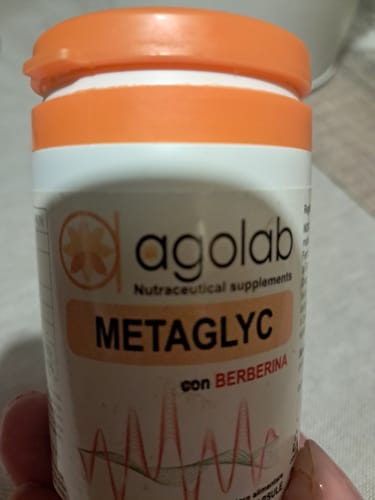 Primo piano del flacone di integratori Metaglyc tenuto in mano da un recensore.