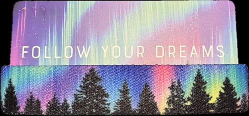 Customer's Follow Your Dreams bracelet and card, showing a vibrant aurora borealis design over dark pine trees.