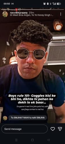 A reviewer wearing the Captain gold and black round sunglasses indoors, looking towards the camera.