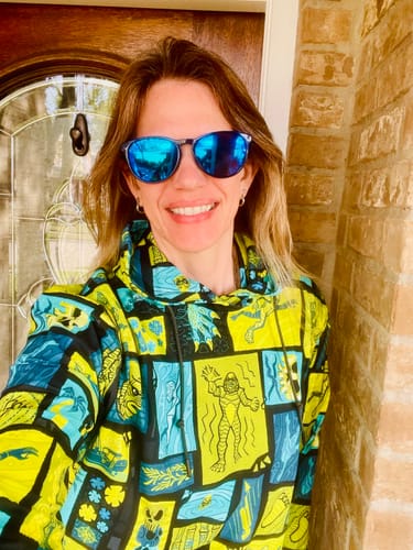 Reviewer smiling in a colorful 'Tiki from the Black Lagoon' performance hoodie.