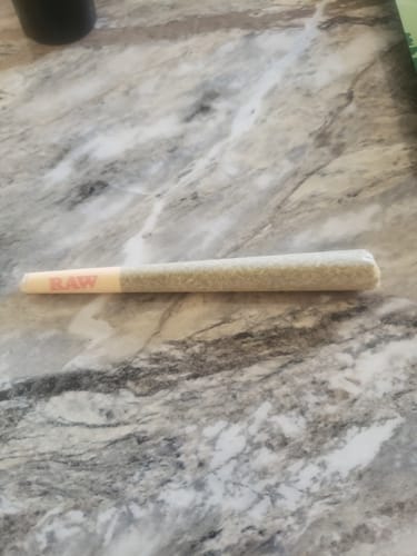 Customer's single Cherry Dosi Do Pre-Roll from the mystery gift lying on a marble-patterned surface.