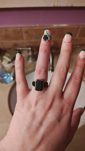 Customer wearing the black Emerald Collection silicone ring with a metal frame on their finger.