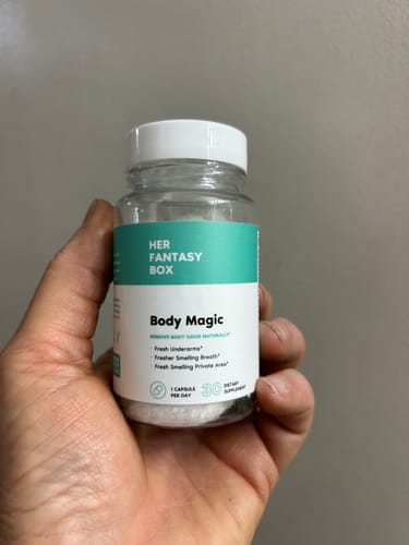 Reviewer holding a clear bottle of the supplement capsules in their hand.