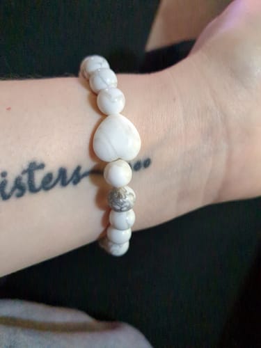 Customer wearing a white Howlite bracelet with a heart-shaped bead on their wrist.