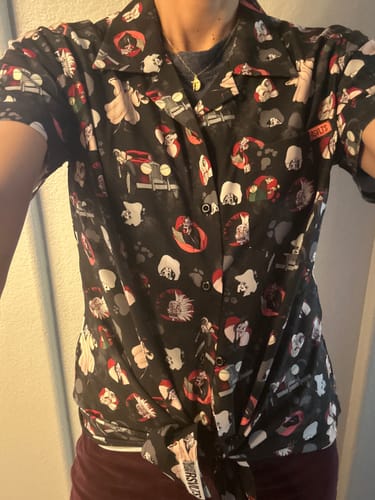 Customer wearing the black Disney 'Perfectly Wretched' short sleeve shirt, which is tied in a knot at the waist.