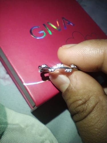 Close-up of a customer holding the shiny Silver Zircon Vine Shine Ring in front of its pink box.