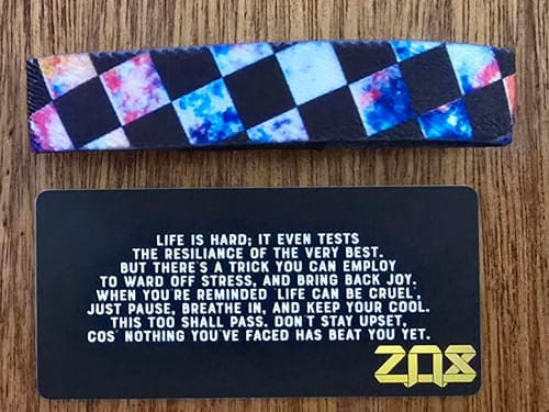 Reviewer shows the inside of the Forever Cool bracelet and the black collector's card with its inspirational message.