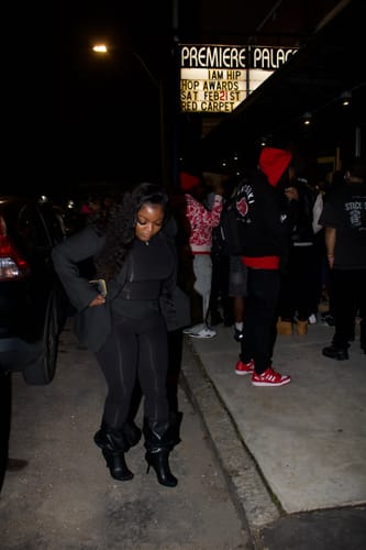 Customer wearing the black Naked Closed Toe Jumpsuit, styled with a jacket and boots for a night out.